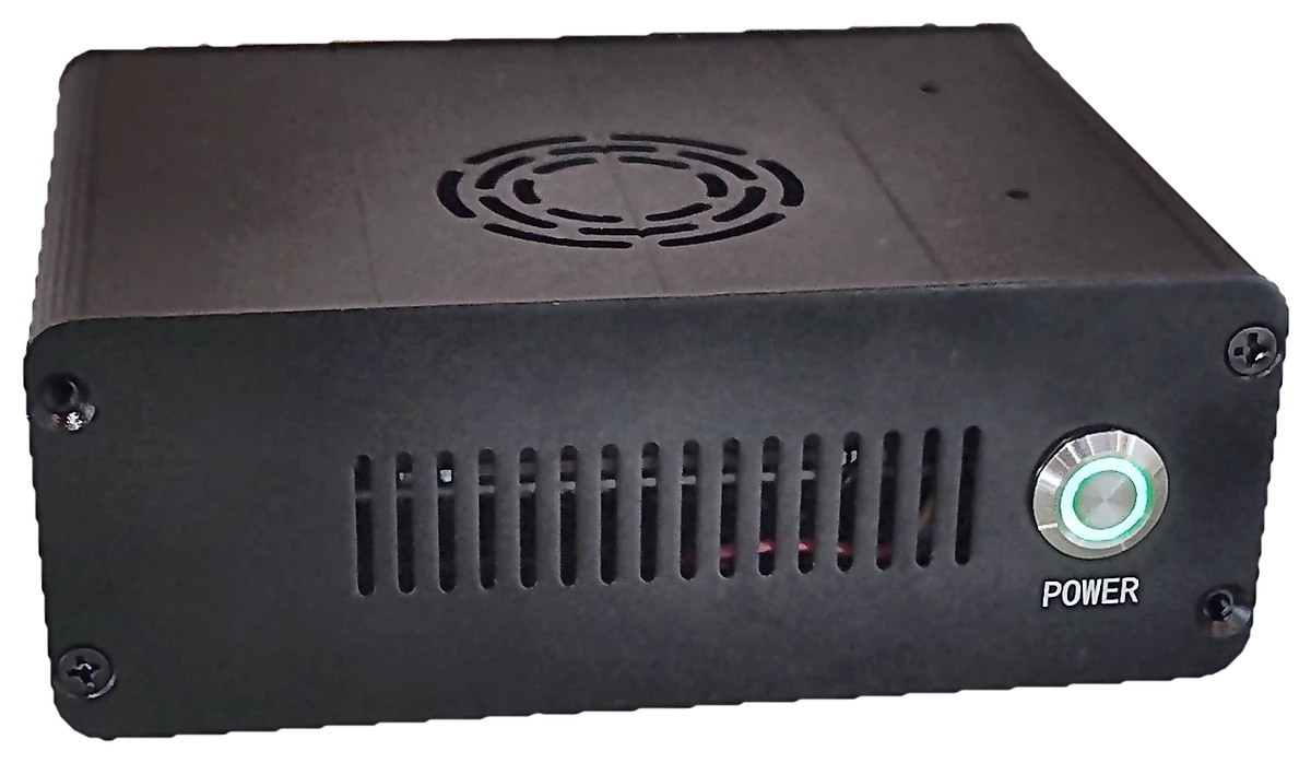 Vista de frente del Observer Node: una caja negra de aluminio con rejillas de ventilación y un botón de encendido con anillo verde iluminado.
